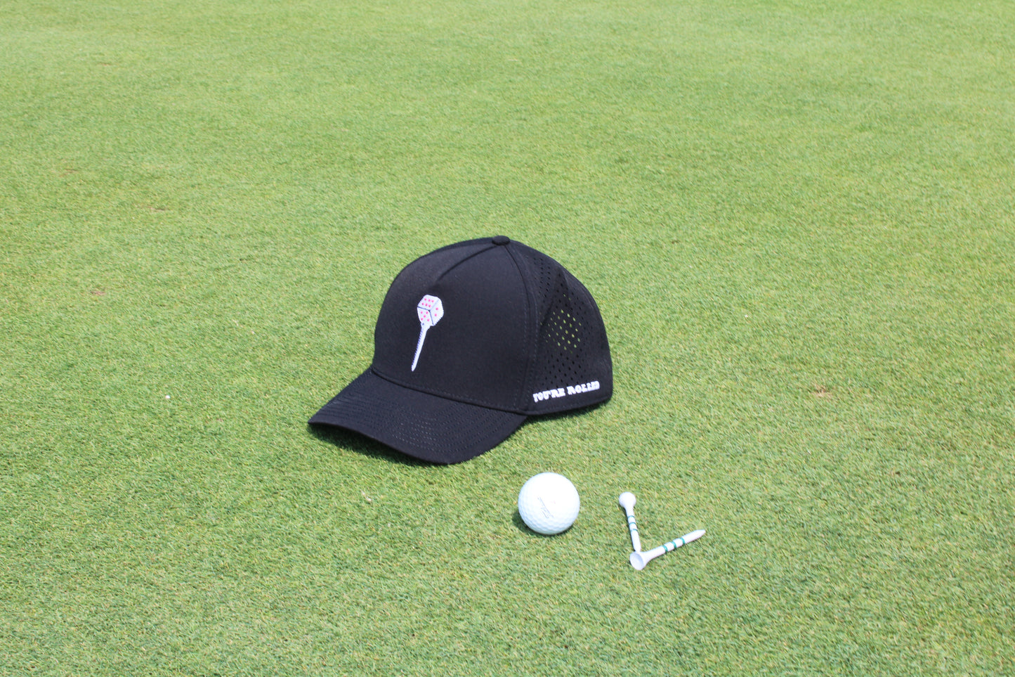 You're Rolled Classic Black hat on the green with a golf ball